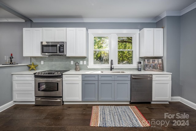 kitchen with decorative backsplash, dark hardwood / wood-style floors, sink, white cabinetry, and appliances with stainless steel finishes