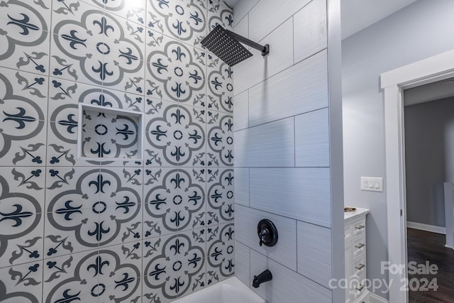 bathroom with vanity, hardwood / wood-style floors, and tiled shower / bath