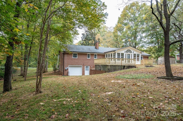 rear view of house with a garage and a deck