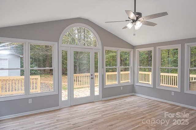 unfurnished sunroom featuring vaulted ceiling, ceiling fan, and plenty of natural light