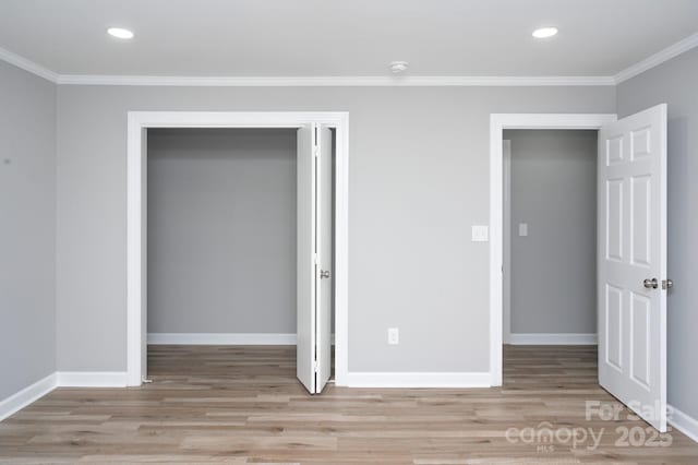 unfurnished bedroom with crown molding, light hardwood / wood-style floors, and a closet