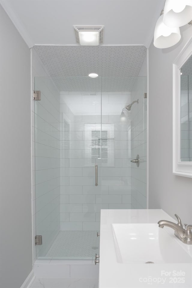 bathroom featuring ornamental molding, vanity, and an enclosed shower