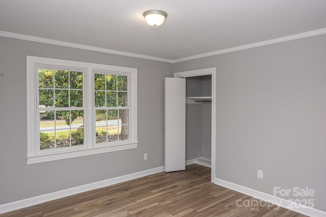 unfurnished bedroom featuring ornamental molding, dark hardwood / wood-style flooring, and a closet