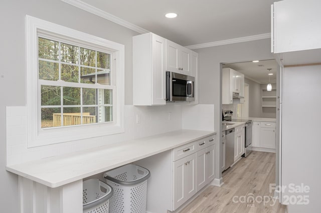 kitchen featuring stainless steel appliances, white cabinetry, backsplash, and light hardwood / wood-style flooring