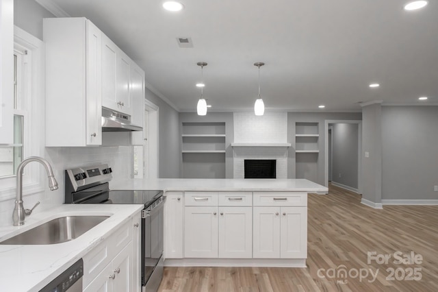 kitchen featuring white cabinetry, sink, kitchen peninsula, and appliances with stainless steel finishes