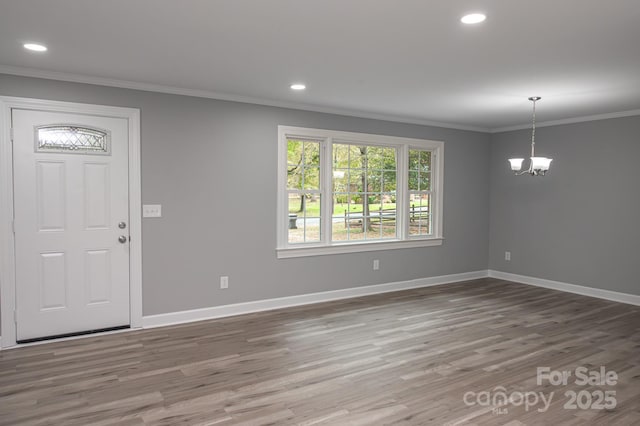 entryway with a notable chandelier, ornamental molding, and dark hardwood / wood-style floors