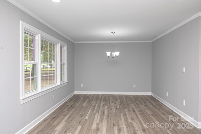 spare room featuring ornamental molding, a chandelier, and light wood-type flooring