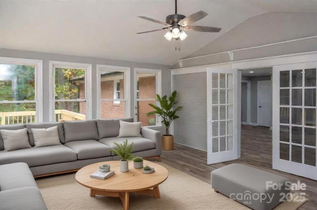 living room featuring lofted ceiling, hardwood / wood-style flooring, french doors, and ceiling fan