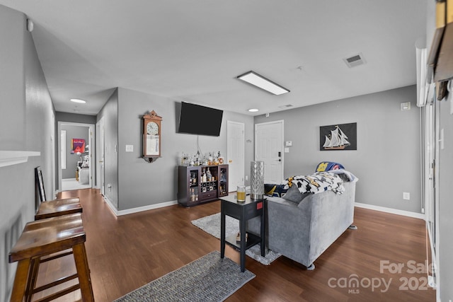 living room with dark wood-type flooring and a fireplace