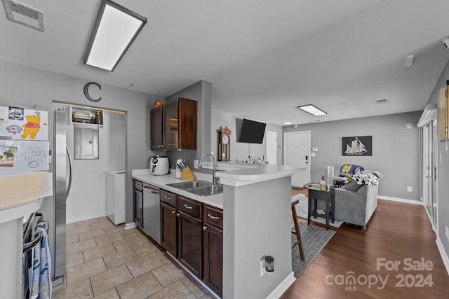 kitchen featuring sink, dark brown cabinets, a breakfast bar, and kitchen peninsula