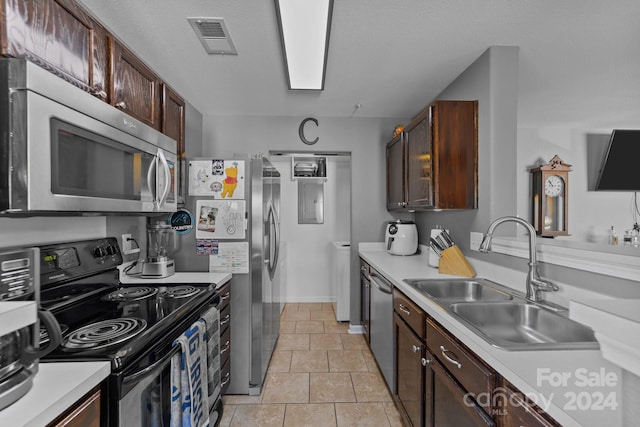 kitchen with appliances with stainless steel finishes, dark brown cabinetry, and sink