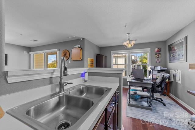 kitchen with a notable chandelier, sink, decorative light fixtures, and dark hardwood / wood-style flooring