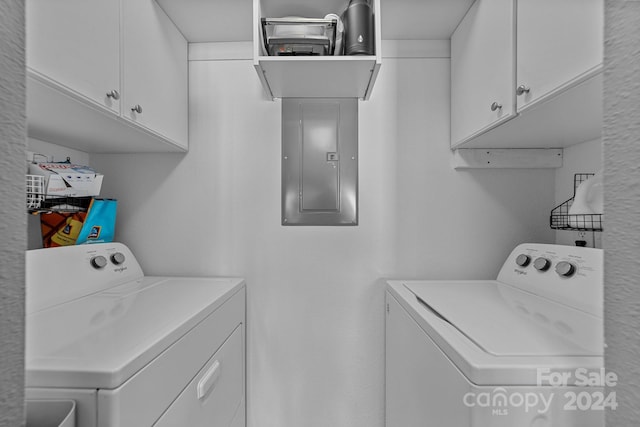 laundry room with electric panel, separate washer and dryer, and cabinets