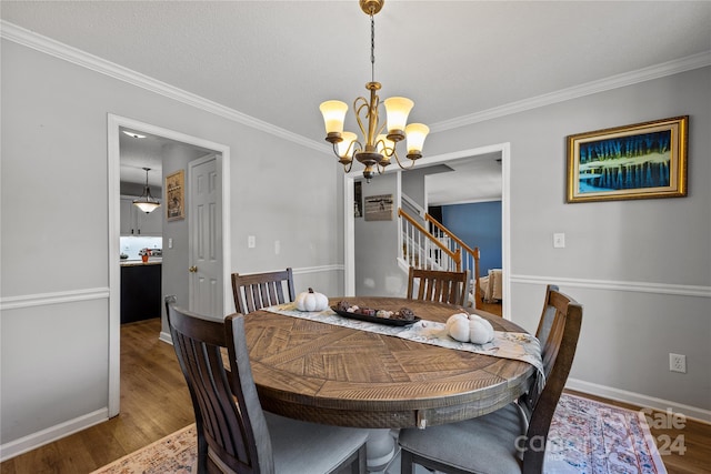 dining room featuring a notable chandelier, crown molding, and hardwood / wood-style flooring