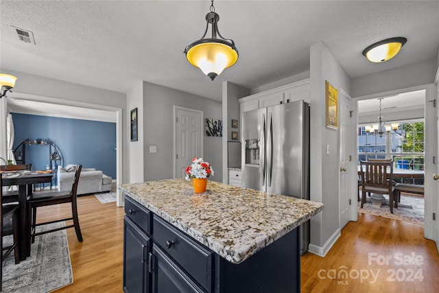 kitchen featuring wood-type flooring, a textured ceiling, and a kitchen island