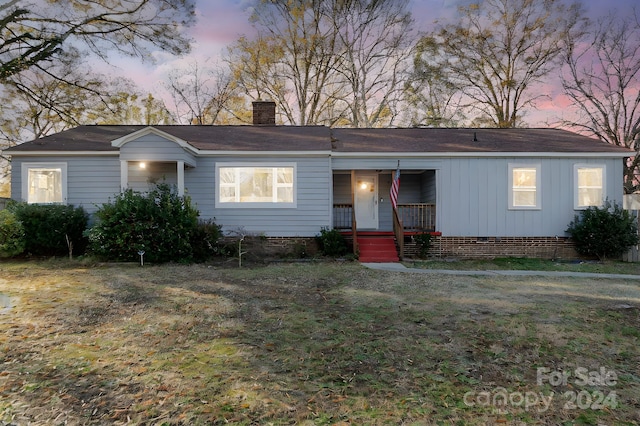 view of front of property with covered porch and a yard