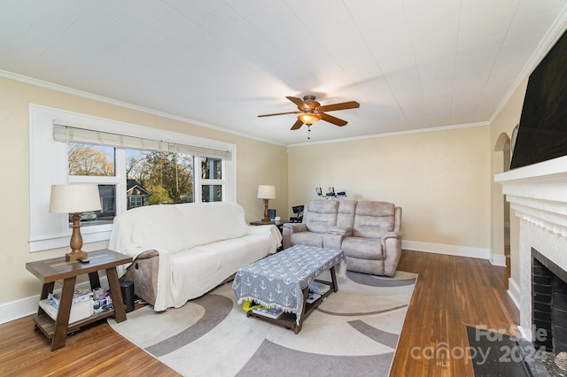 living room with crown molding, a fireplace, and wood-type flooring