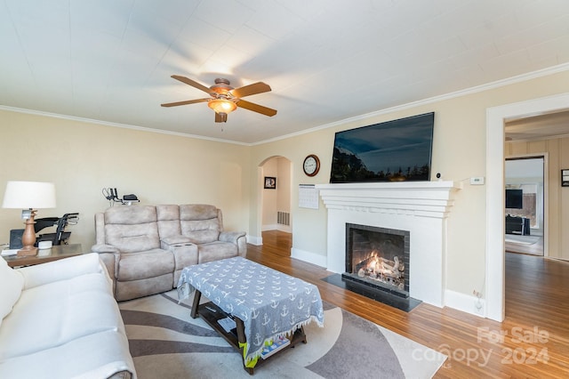 living room featuring ceiling fan, wood-type flooring, and crown molding