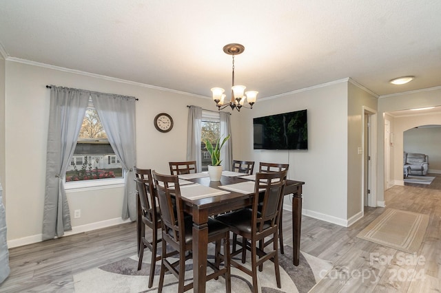 dining room featuring hardwood / wood-style floors, ornamental molding, and a chandelier