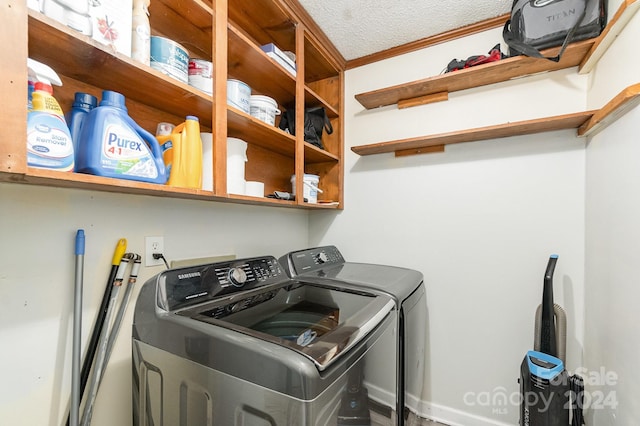 clothes washing area with a textured ceiling and washing machine and clothes dryer