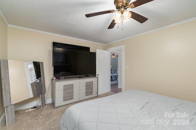 carpeted bedroom featuring ceiling fan and ornamental molding