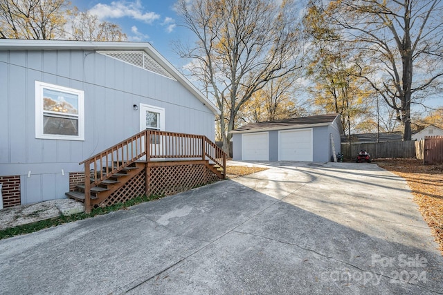 view of side of home with a wooden deck, an outbuilding, and a garage