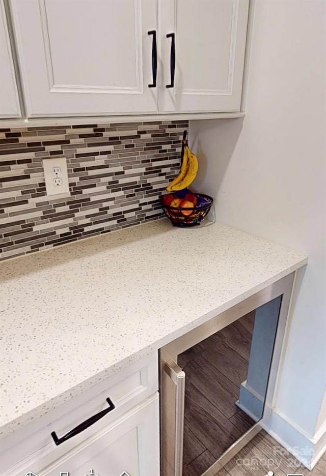 details featuring white cabinets, tasteful backsplash, and light stone counters