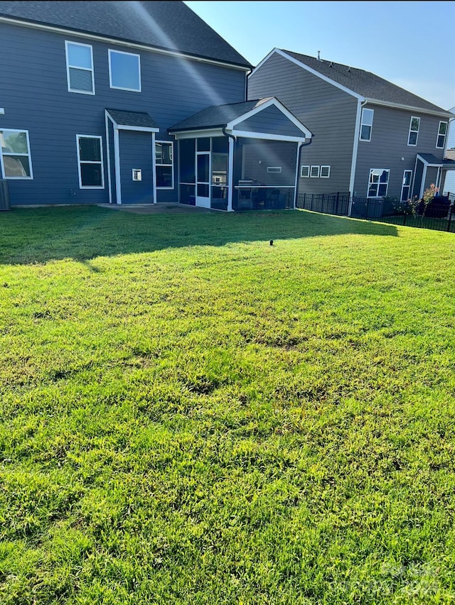 back of house with a lawn and a sunroom