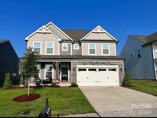 craftsman house with a front yard and a garage