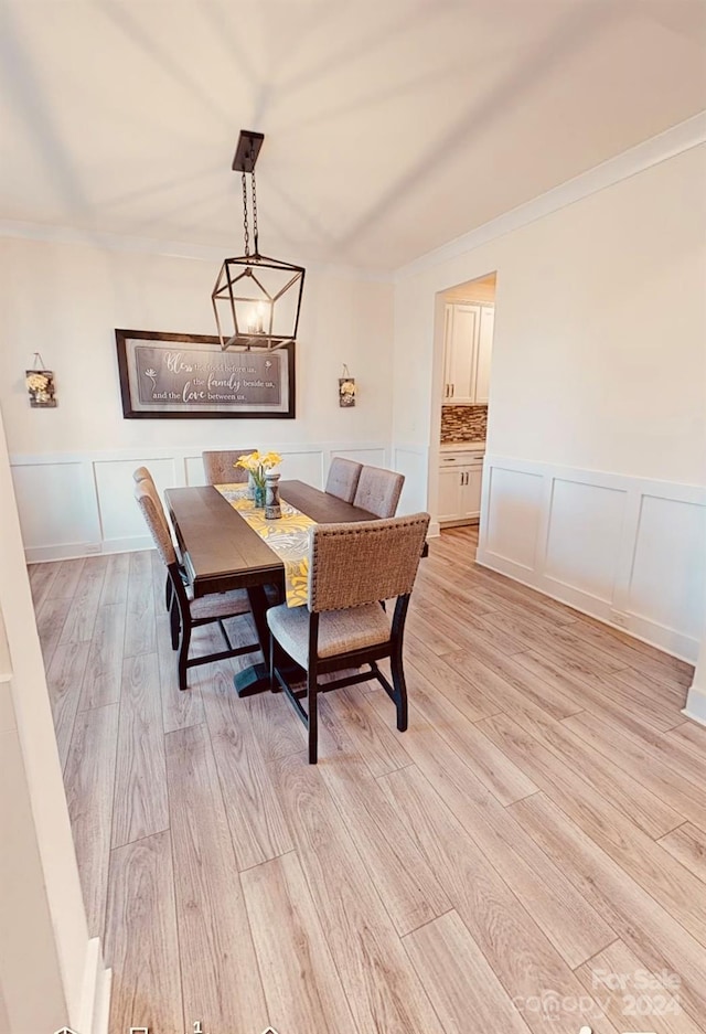 dining space featuring ornamental molding and light wood-type flooring