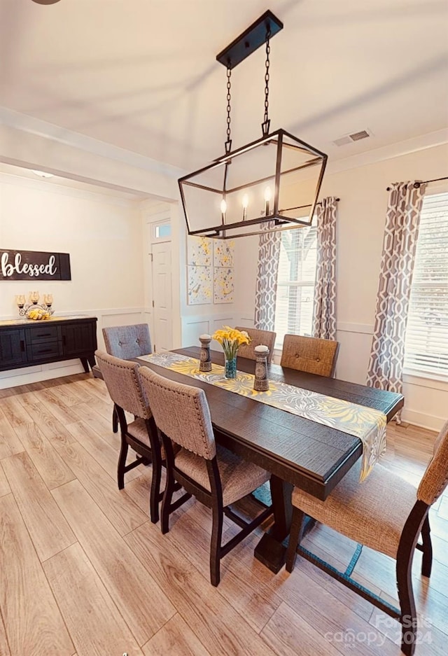 dining room featuring light hardwood / wood-style flooring, a notable chandelier, and a healthy amount of sunlight