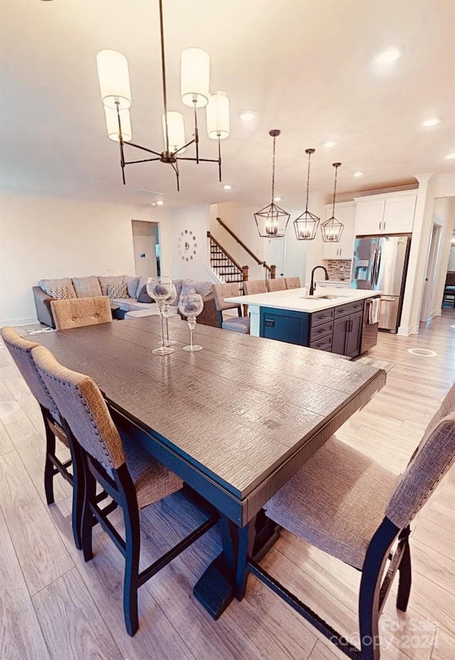 dining area with sink and light wood-type flooring