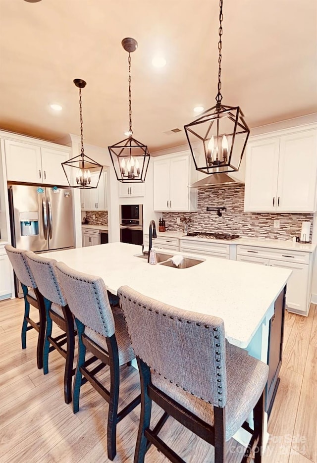 kitchen with light hardwood / wood-style flooring, decorative light fixtures, and white cabinetry