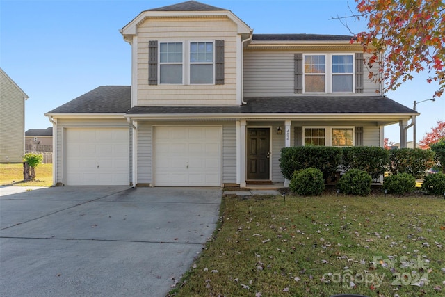 front facade with a front yard, covered porch, and a garage