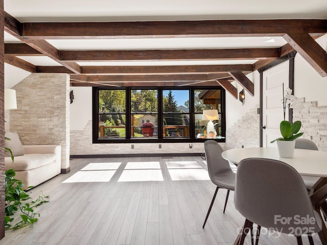 interior space featuring beamed ceiling and wood finished floors