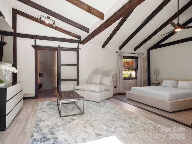 bedroom featuring light wood finished floors, beam ceiling, high vaulted ceiling, and a barn door