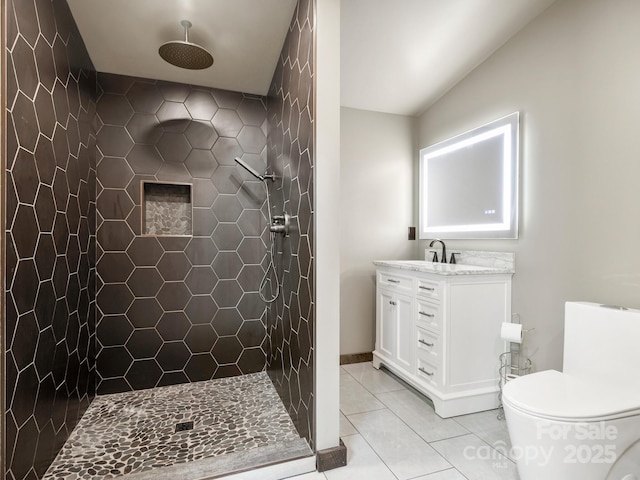 full bathroom with tile patterned flooring, toilet, vanity, and tiled shower