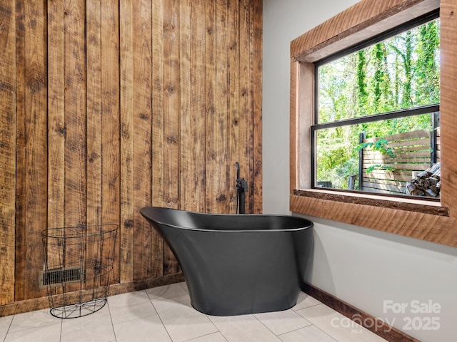 full bathroom with a soaking tub and tile patterned flooring