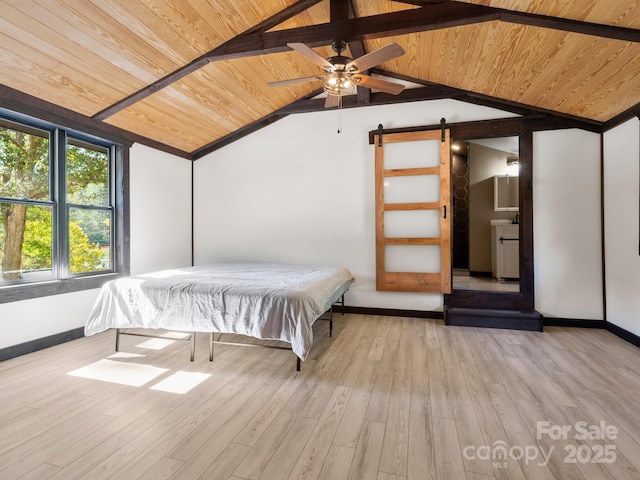 unfurnished bedroom featuring wood ceiling, light wood finished floors, and a barn door