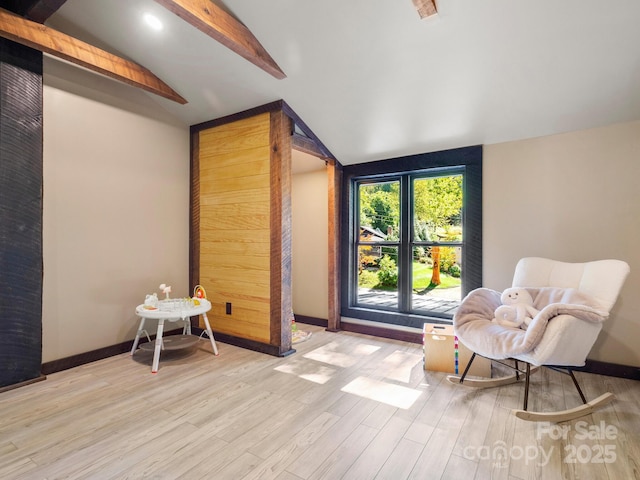 sitting room with lofted ceiling with beams, baseboards, and wood finished floors