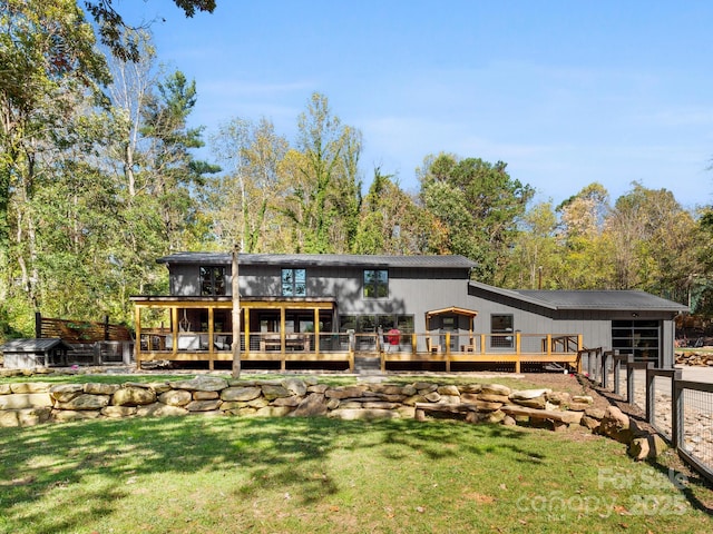 rear view of property with an attached garage and a wooden deck