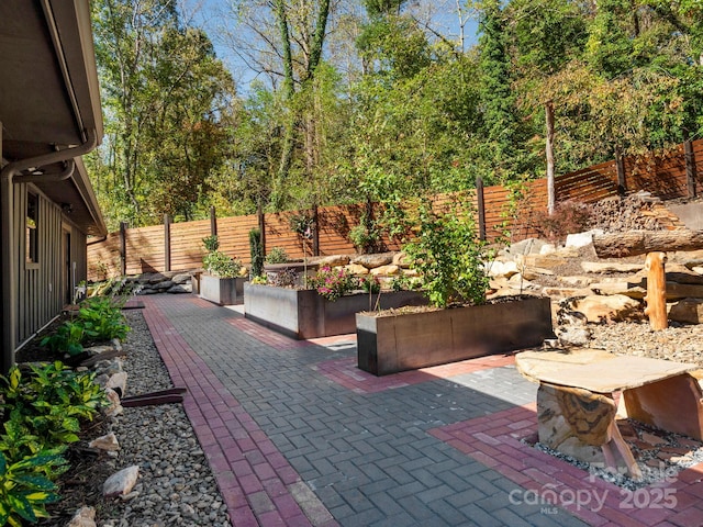 view of patio featuring a fenced backyard and a vegetable garden