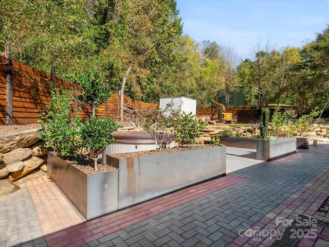 view of patio / terrace with an outbuilding and fence