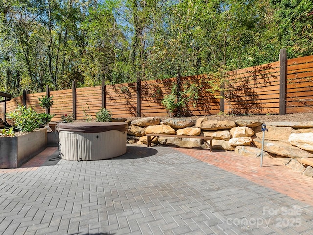 view of patio / terrace featuring a fenced backyard and a hot tub