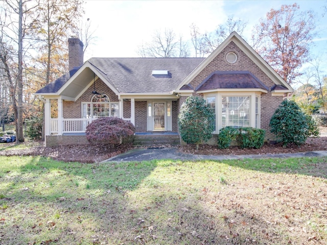 ranch-style home featuring covered porch and a front lawn