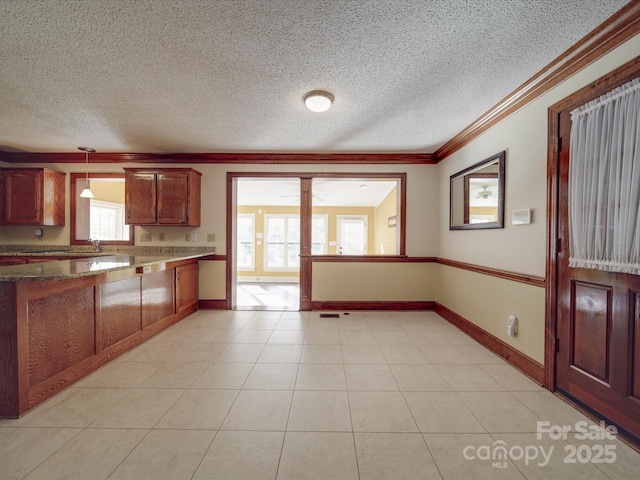 kitchen featuring crown molding, pendant lighting, a textured ceiling, and light tile patterned flooring