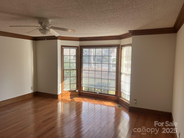 empty room featuring hardwood / wood-style floors, crown molding, a textured ceiling, and ceiling fan