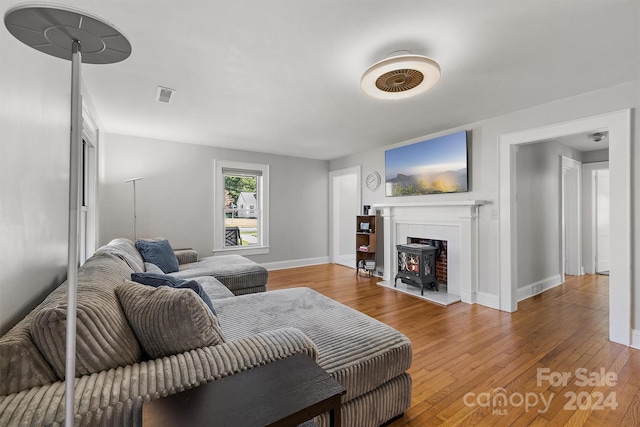 living room with wood-type flooring and a wood stove