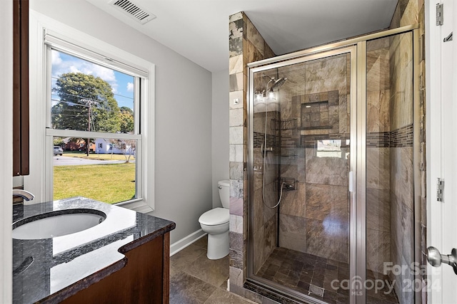 bathroom featuring vanity, toilet, and a shower with door