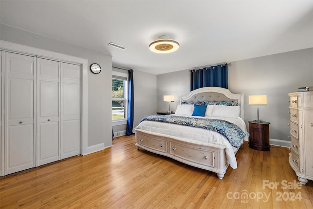 bedroom with light hardwood / wood-style floors and a closet